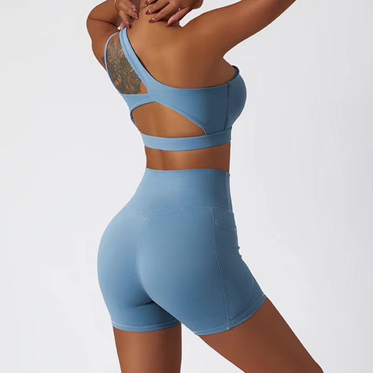 A woman posing in a matching set consisting of a cut-out sports bra and shorts in light blue color