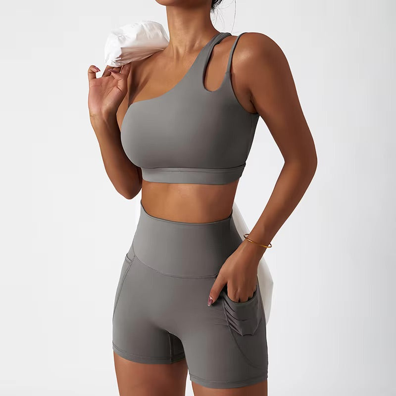 A woman posing in a matching set consisting of a cut-out sports bra and shorts in brown color