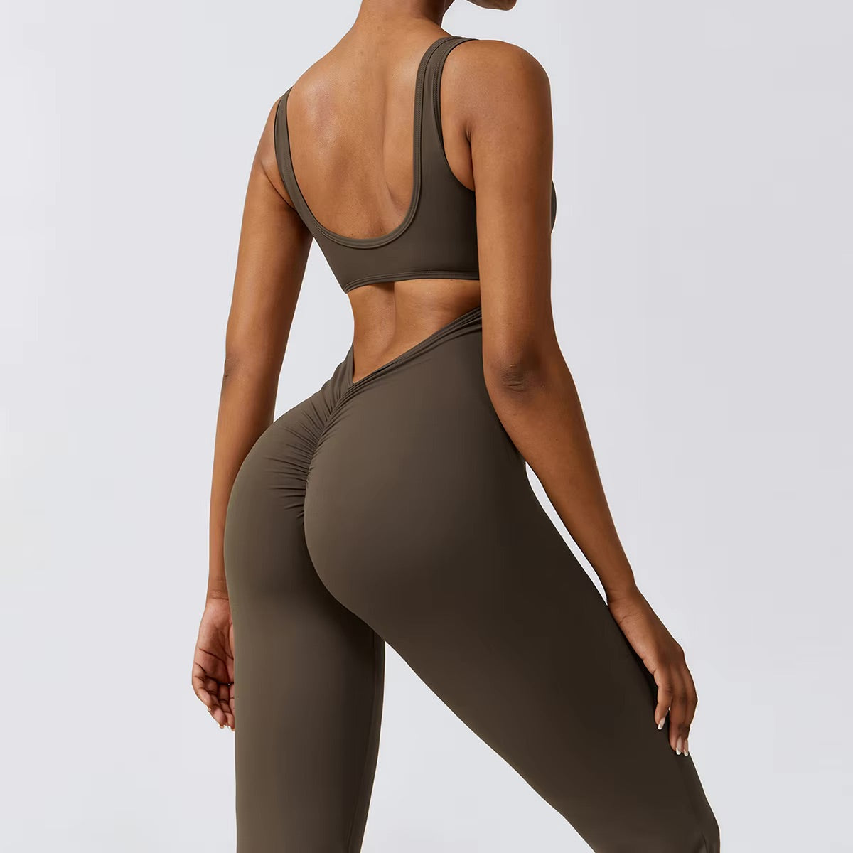 Woman posing in a brown yoga jumpsuit