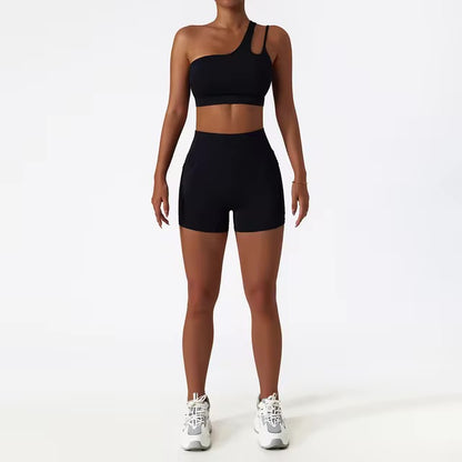 A woman posing in a matching set consisting of a cut-out sports bra and shorts in black color