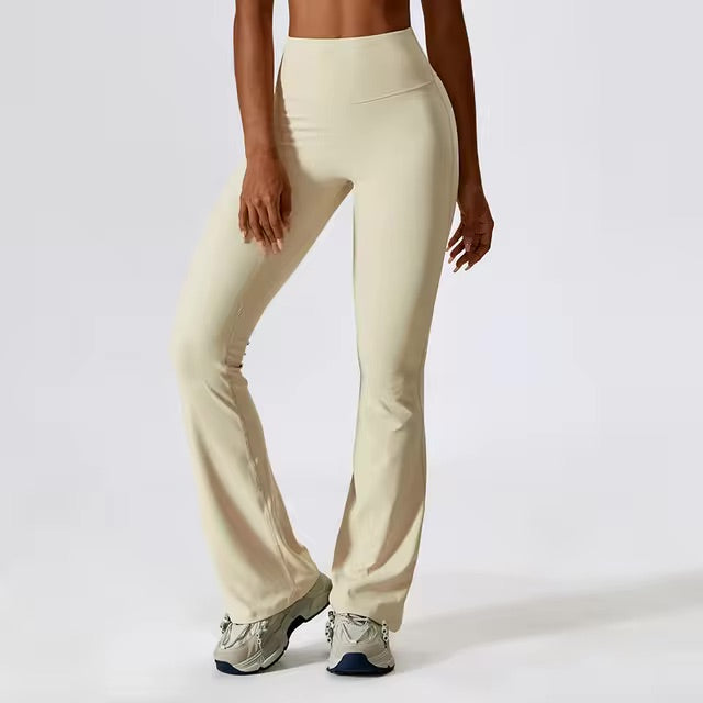 A woman posing in high-waisted, beige leggings