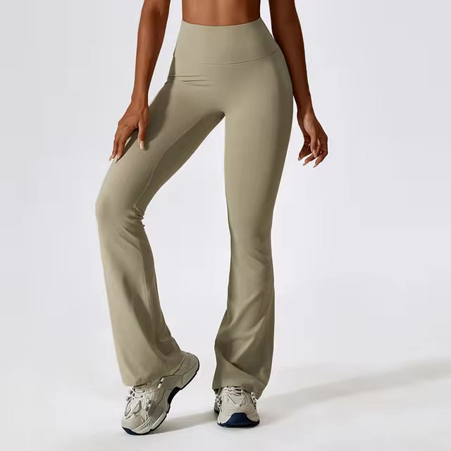 A woman posing in high-waisted, olive green leggings