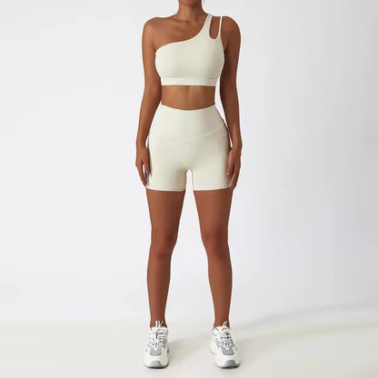 A woman posing in a matching set consisting of a cut-out sports bra and shorts in white color