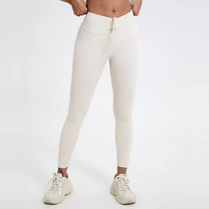 A woman posing in high-waisted, white leggings