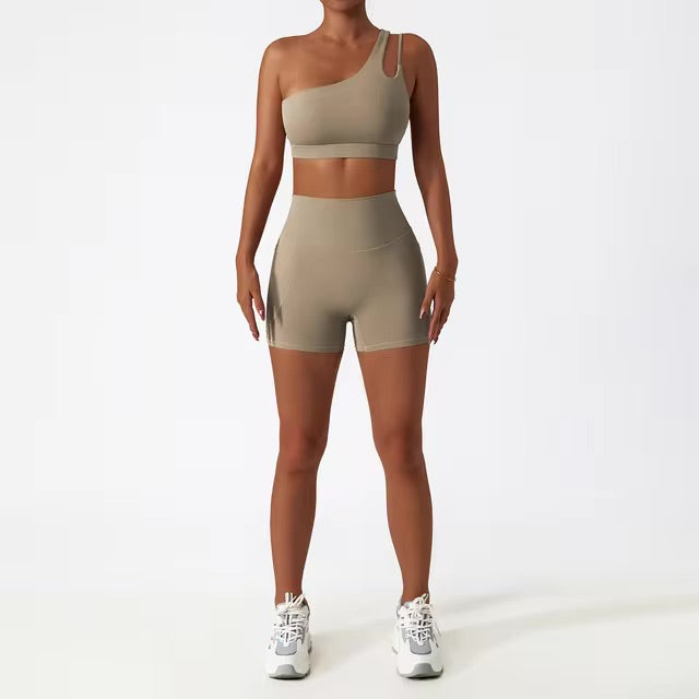 A woman posing in a matching set consisting of a cut-out sports bra and shorts in brown color