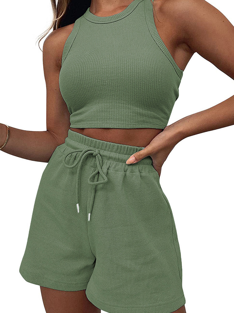 Woman posing in an olive green, waffle knit set consisting of shorts and a crop top