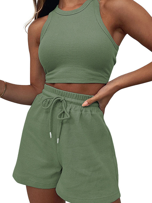 Woman posing in an olive green, waffle knit set consisting of shorts and a crop top