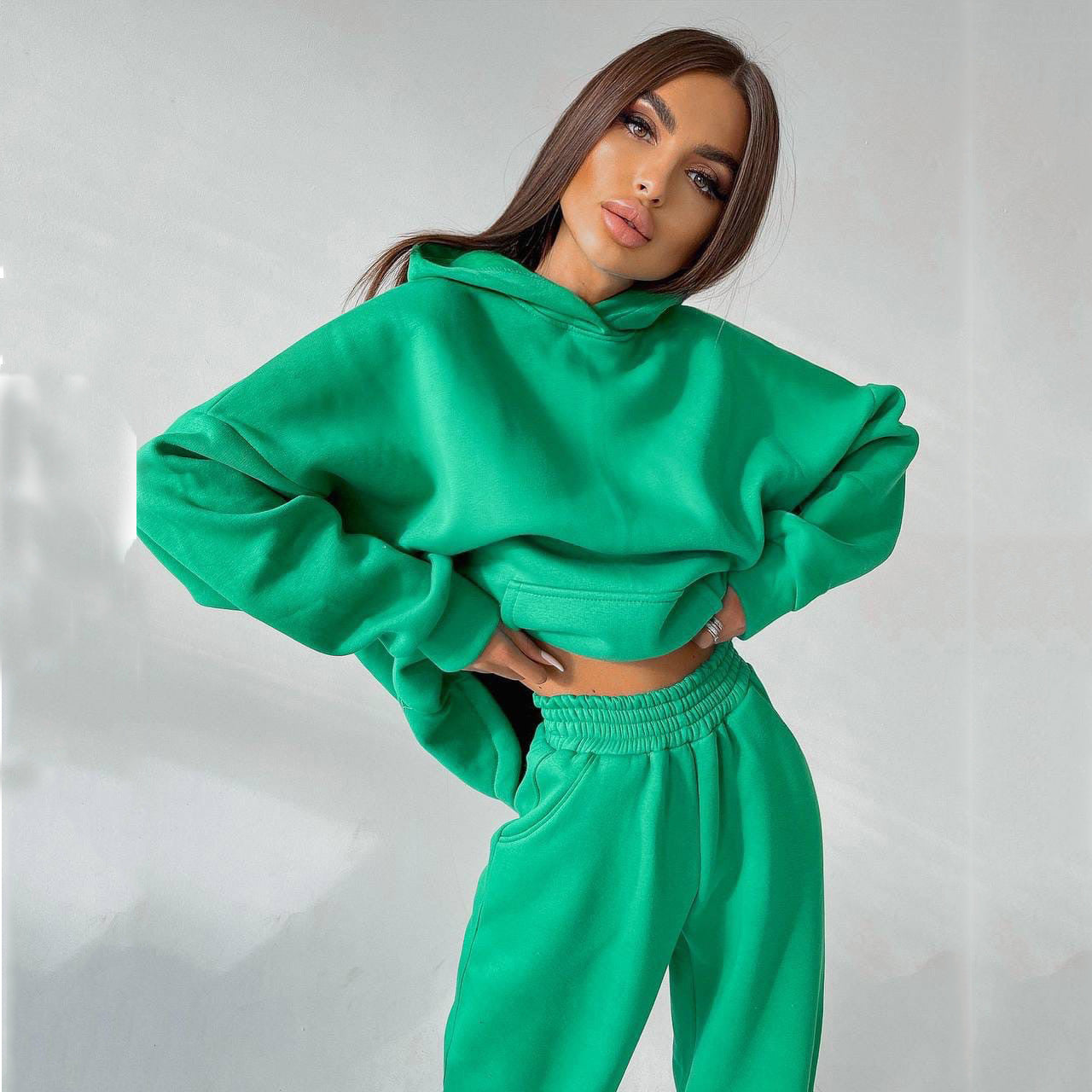 A woman posing in a green oversized hoodie with matching sweatpants