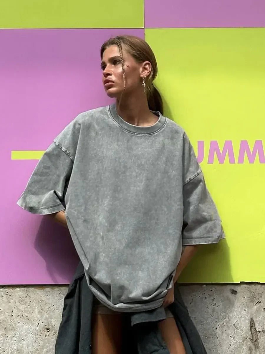 A woman posing in a grey, oversized t-shirt