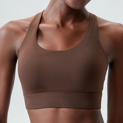 A woman posing in a brown sports bra 