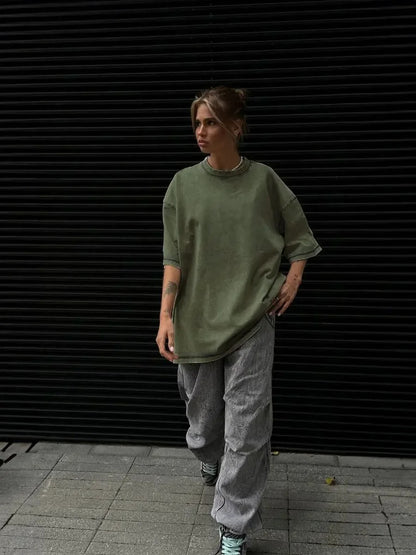 A woman posing in an olive green, oversized t-shirt