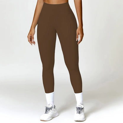 A woman posing in brown leggings