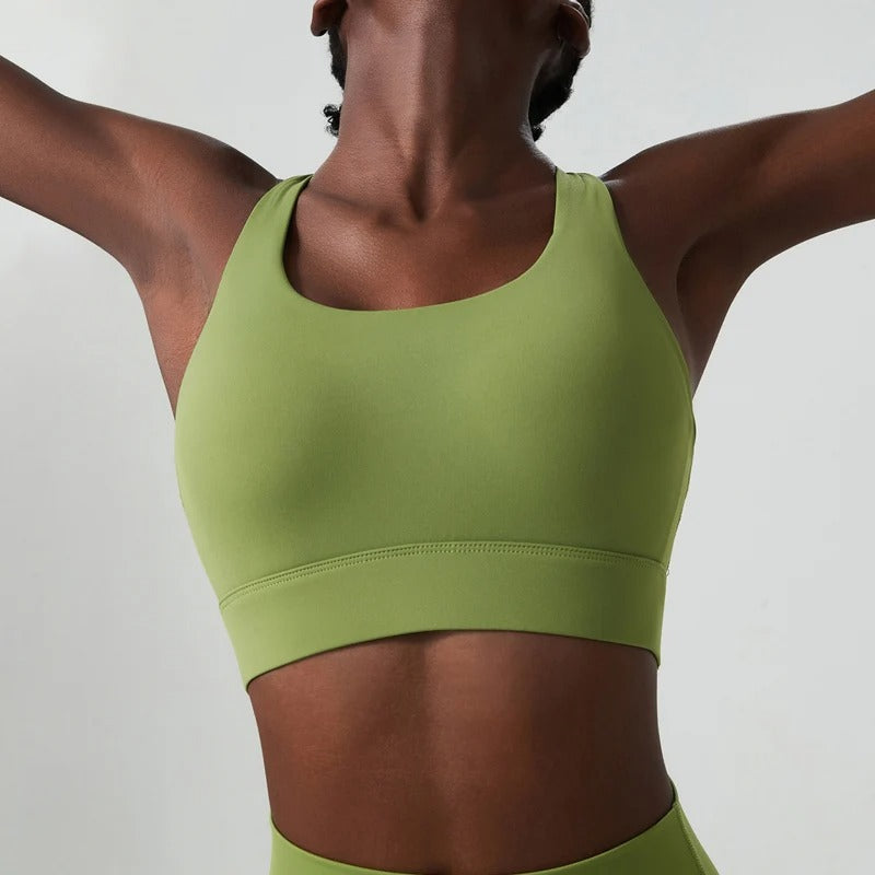 A woman posing in a green sports bra 