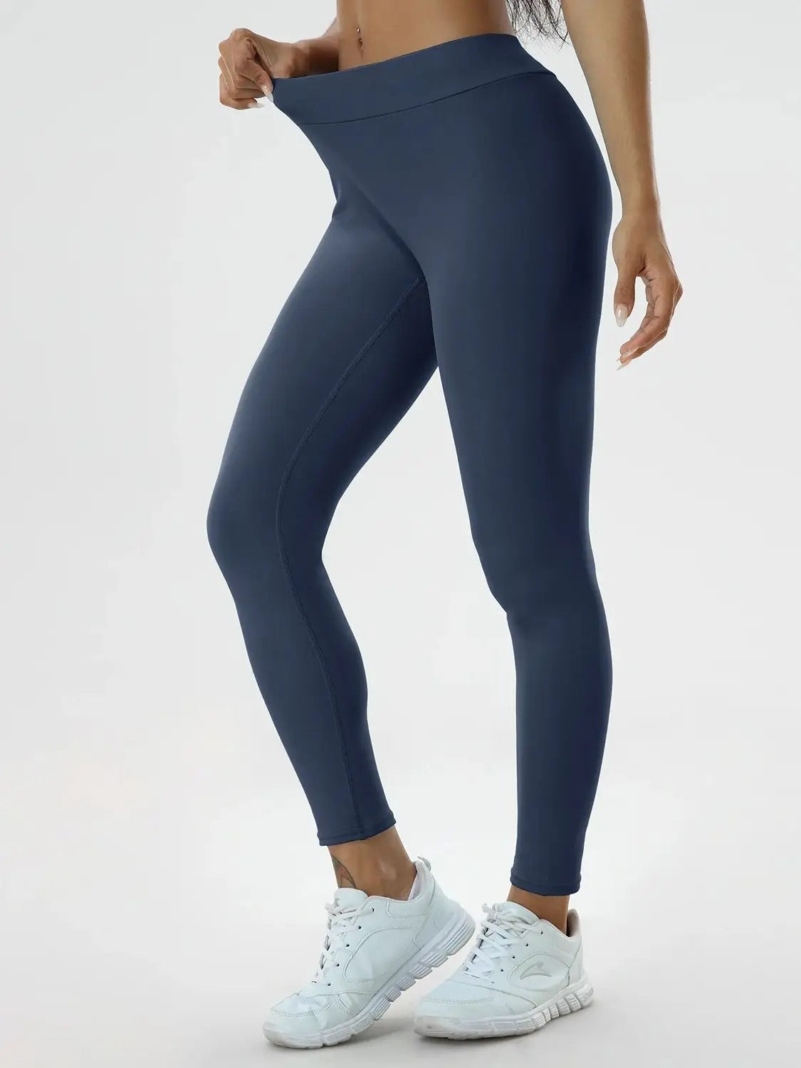 Woman posing in blue leggings