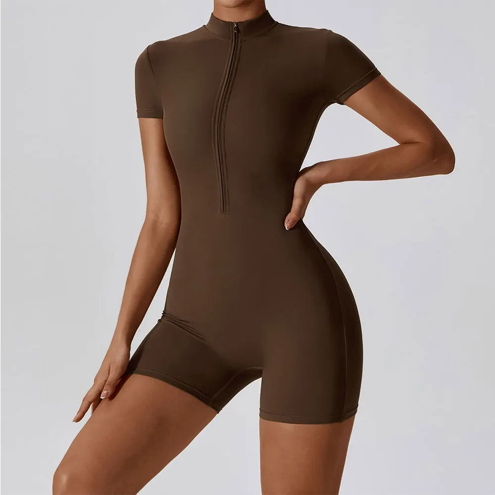 A woman posing in a brown, short-sleeve yoga bodysuit