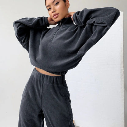 A woman posing in a matching set consisting of a sweatshirt and sweatpants