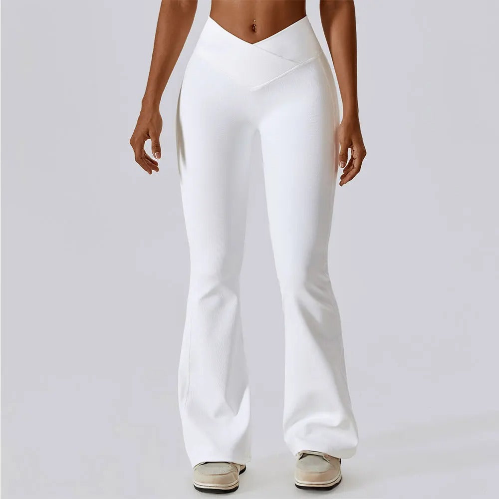 A woman posing in white leggings