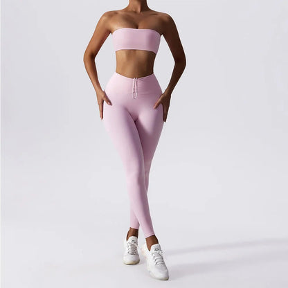 Woman posing in a light pink, matching workout set consisting of a sports bra and high waisted leggings