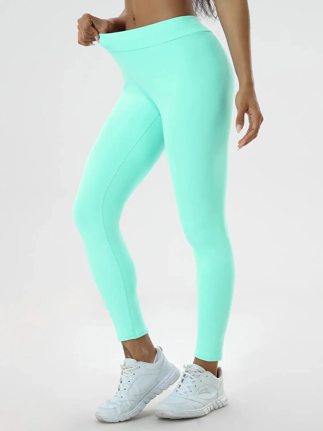 Woman posing in mint colored leggings