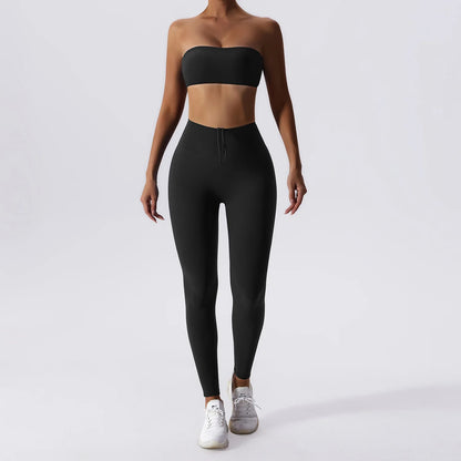 Woman posing in a black, matching workout set consisting of a sports bra and high waisted leggings