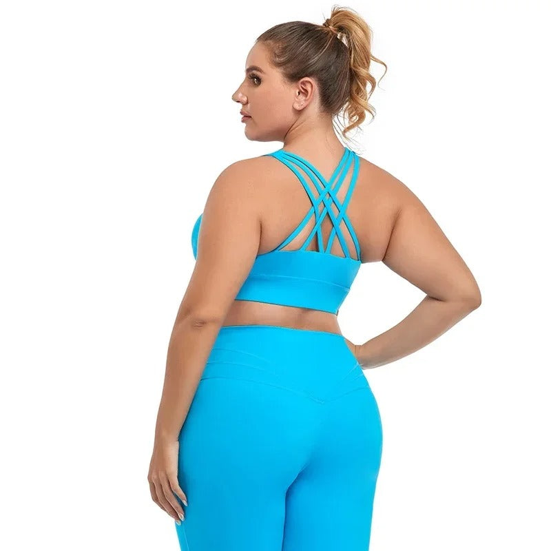 A woman posing in a light blue sports bra with matching leggings