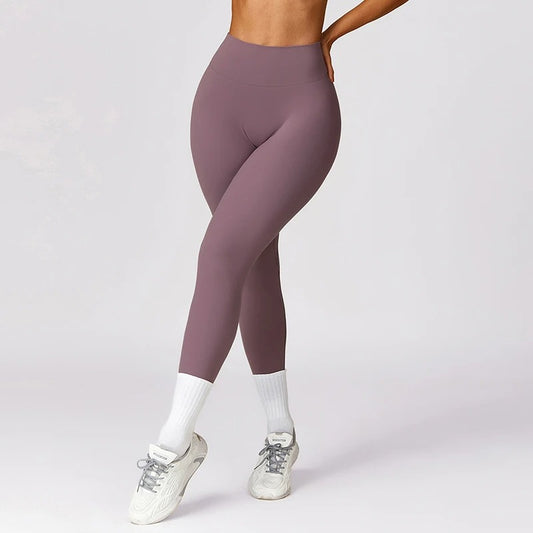 A woman posing in purple leggings