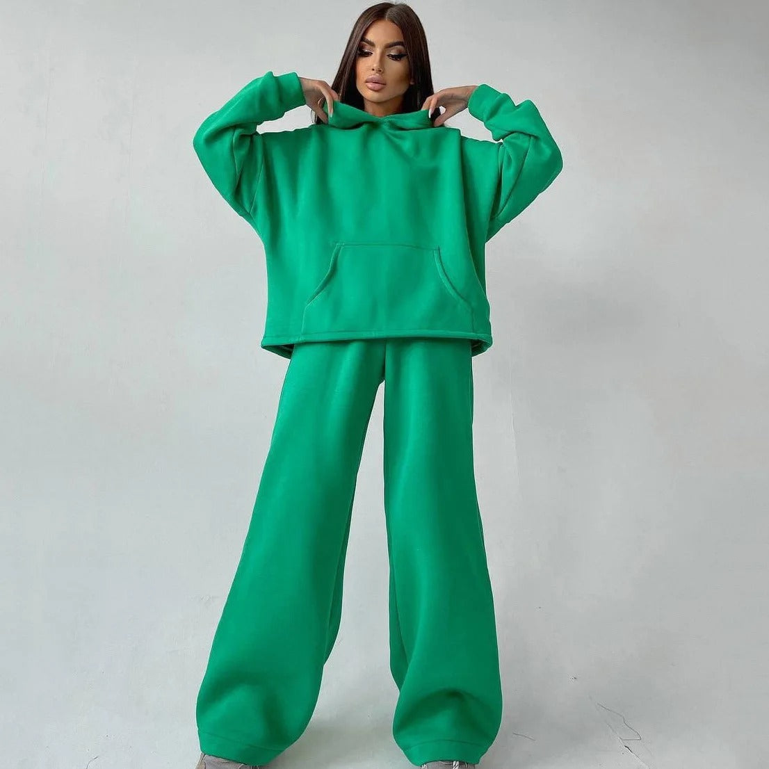 A woman posing in a green oversized hoodie with matching sweatpants