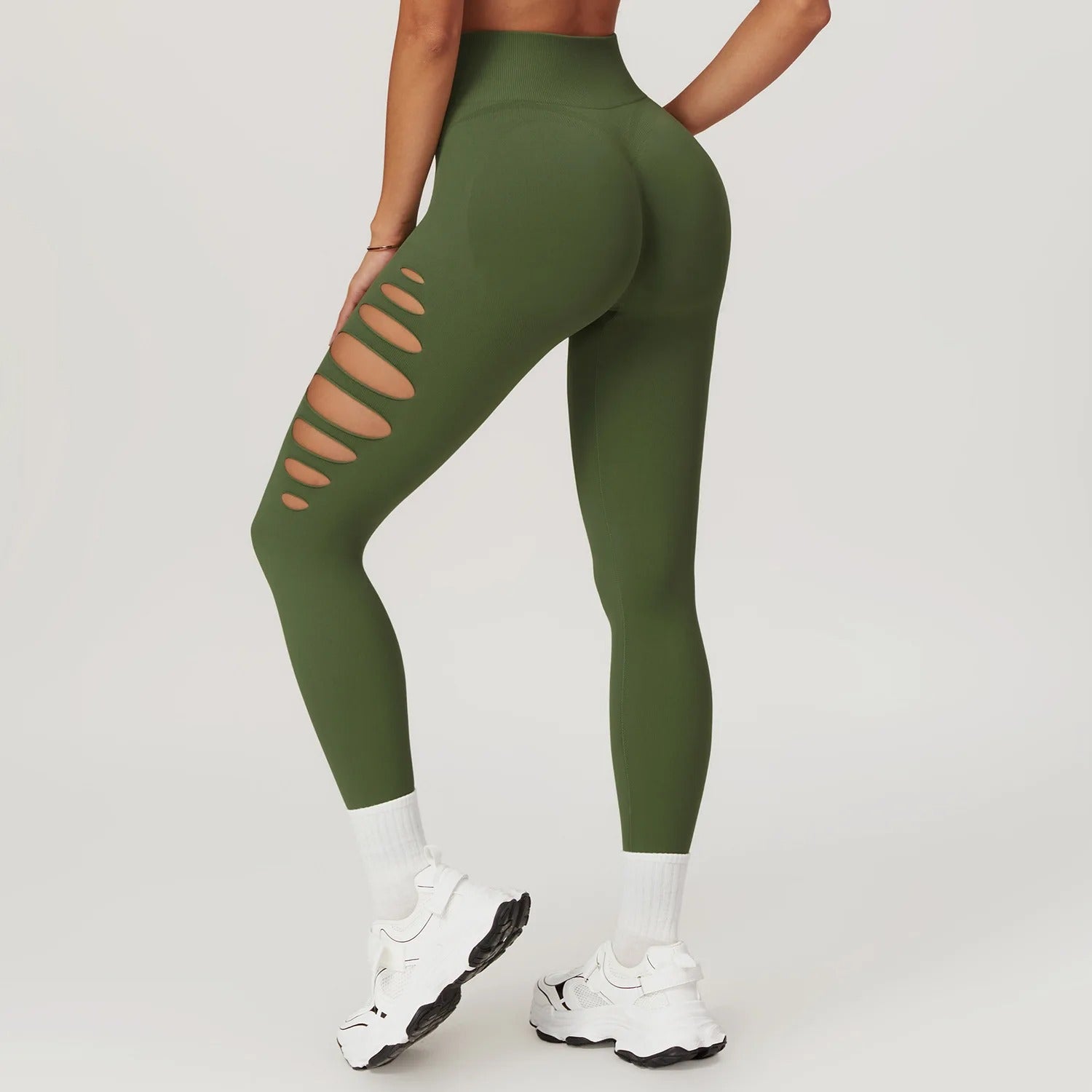 A woman in green yoga pants with holes on the sides