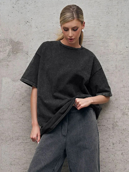 A woman posing in a black, oversized t-shirt