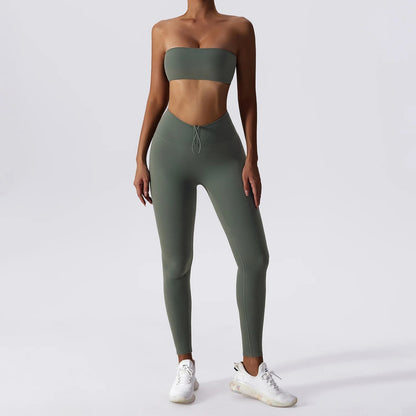 Woman posing in an olive green, matching workout set consisting of a sports bra and high waisted leggings