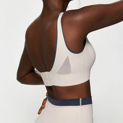 Woman posing in a white workout set consisting of leggings and a sports top