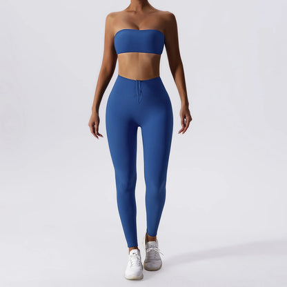 Woman posing in a blue, matching workout set consisting of a sports bra and high waisted leggings