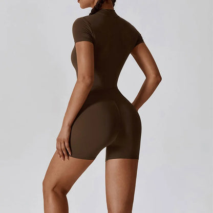 A woman posing in a brown, short-sleeve yoga bodysuit