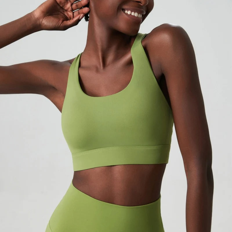 A woman posing in a green sports bra 