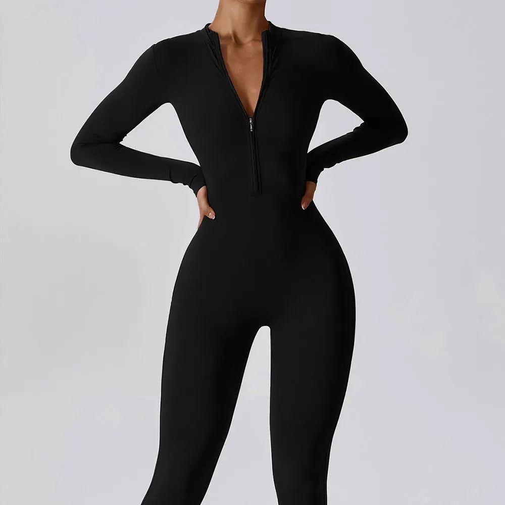 Woman posing in a long- sleeved, black, yoga jumpsuit with a zipper