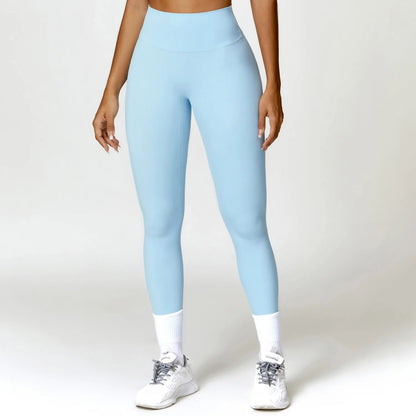 A woman posing in light blue leggings