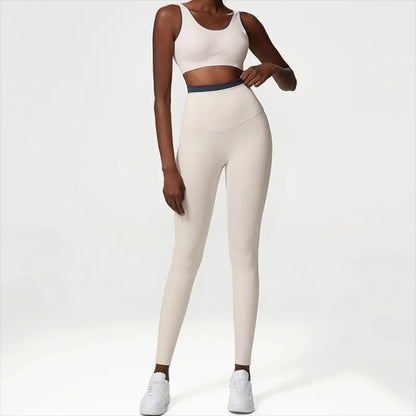 Woman posing in a white workout set consisting of leggings and a sports top