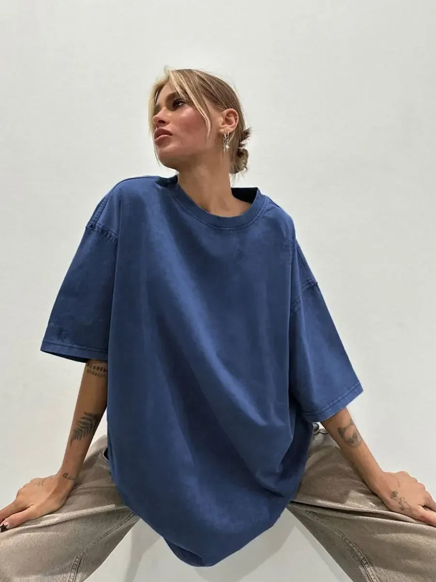 A woman posing in a blue, oversized t-shirt