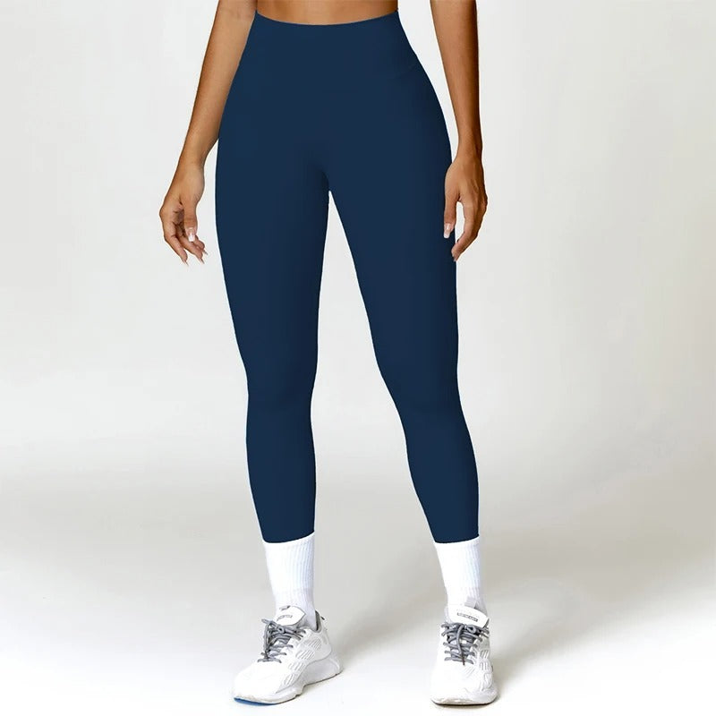 A woman posing in dark blue leggings