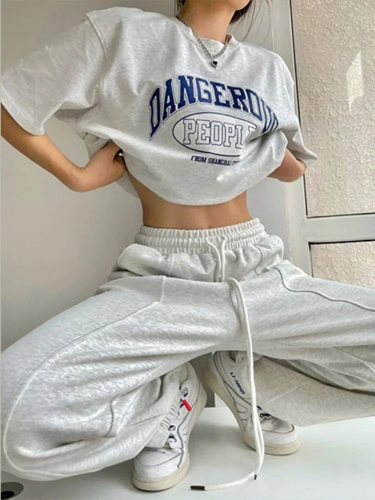 Woman posing in wide legged, white sweatpants