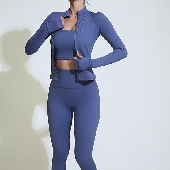 Woman posing in a blue sports top with a zipper and matching leggings