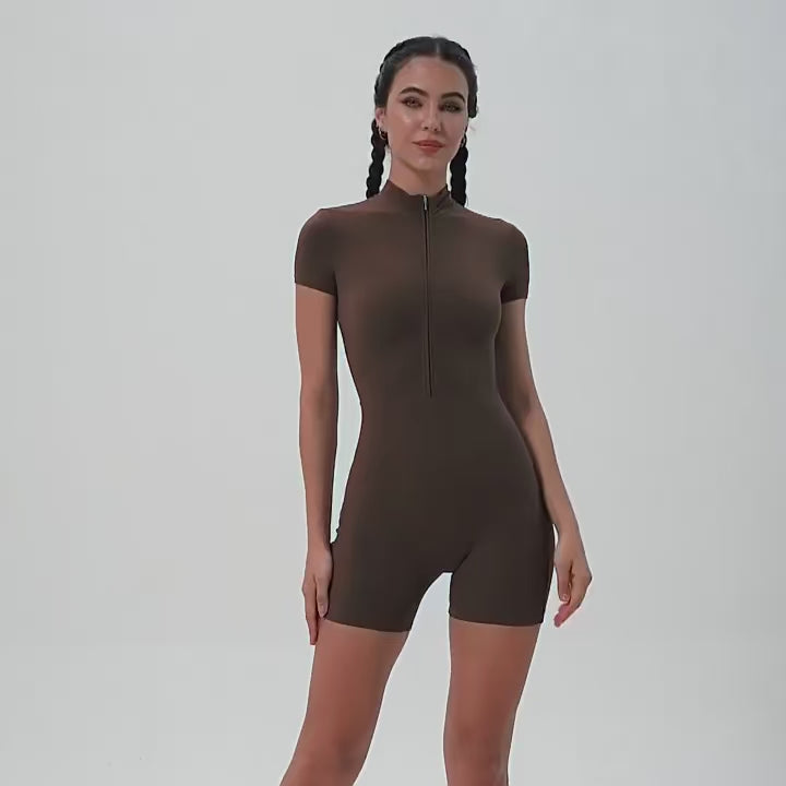 A woman posing in a brown, short-sleeve yoga bodysuit