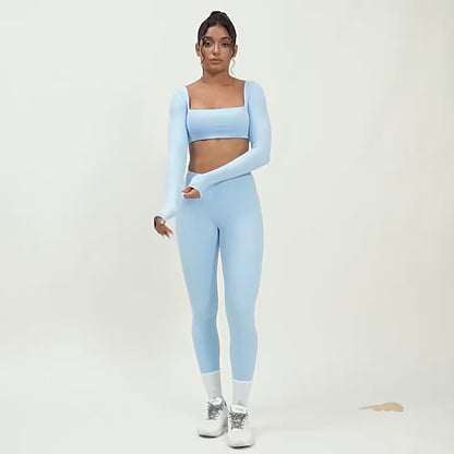 A woman posing in light blue leggings and a matching sports top