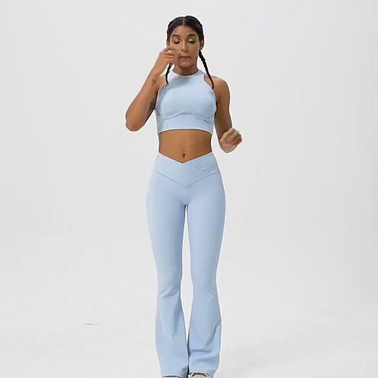 A woman posing in light blue leggings and a matching sports bra